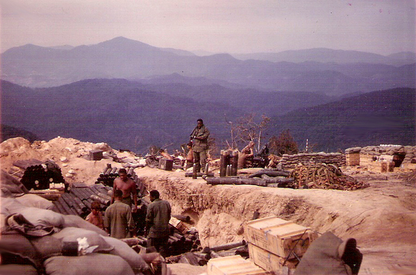 Cambodia in the distance
Spring, 1968, LZ Mickey Mouse (possibly this is "A" Battery").  View southwest from LZ Mile High; Cambodia in distance.  Black tubes in pile are 105mm ammo canisters (2 per box).
