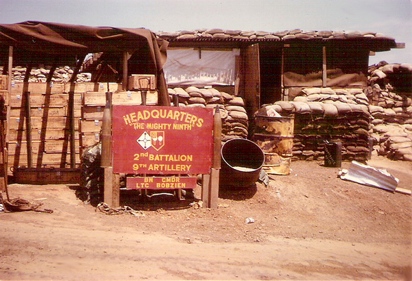 Bn CO LTC Jerry Bobzien, 2/9th
Spring, 1968.  LZ English was just outside Bong Son, to the south of Duc Pho where we had been months before.  We stayed here only about a month.  The base, fortunately, had been occupied, so it was already built for us.  Our FDC bunker is behind the sign.
