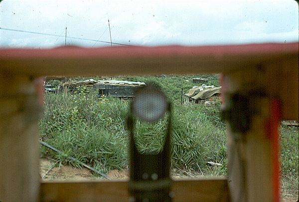 Collimnator replaces Aiming Stakes
"High Tech" arrives in Vietnam.  The brand new tool called a "collimnator" provides a gunner with a superior tool replacing the red & white banded aiming stakes.  Only problem was that Ft Sill hadn't counted on the 110% humidity and the sight glasses fogging up.  Stakes were still needed.  Also, protective boxes had to be constructed.
