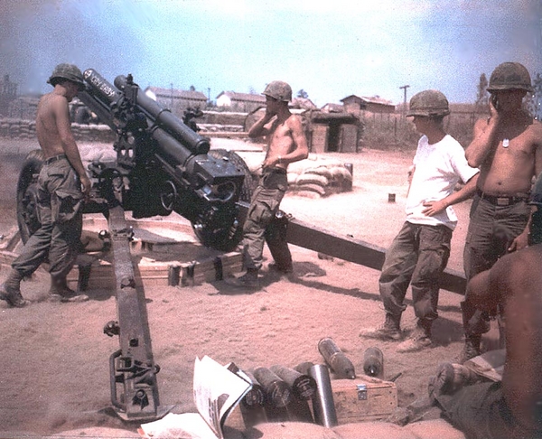 Fire Mission!
Contributed by Sp4 J. William Ward of "B" Battery.  Location is "Kontum City", 1968.  Tube is nicknamed "Cry Baby".  Note the use of non-standard military ear protection devices (fingers).  No wonder we're all retired and deaf.
