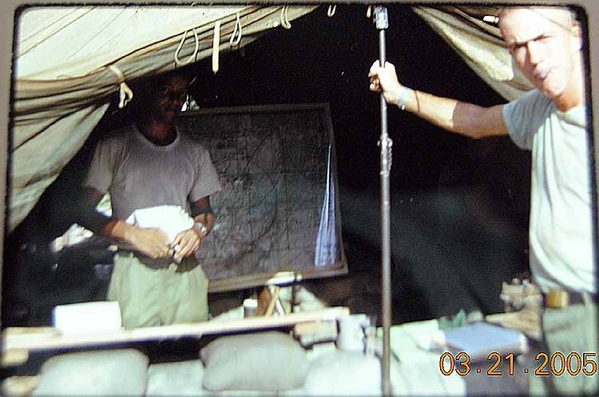 The FDC Tent
Sp4 James McBrayer, Jr.  inside; Battery Commander Capt Frederick C. Rice outside holding tent pole.
