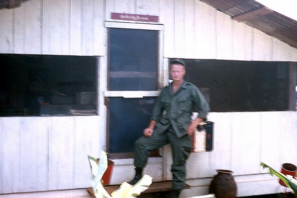 UNK soldier stands in front of the Orderly Room door.
