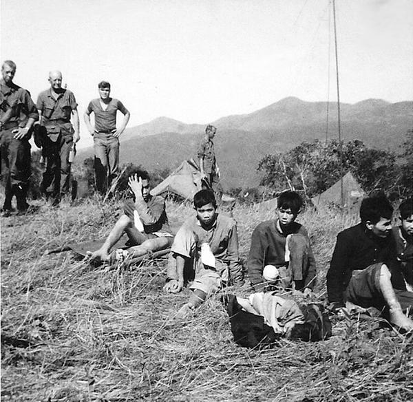 VC Prisoners
Members of 1/35 Inf Regt looking over some VC prisoners at LZ Tip, Feb 67.  In the center background is Maj Gerrold Tippin, S-3, 1/35 Inf Regt.
