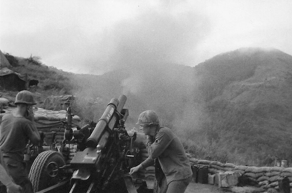 "On the Way"
Photo catches the perfect angle of recoil.  Cpl John Kuntz is the Gunner and Sp4 John Waldman is the Asst Gunner.  Fire mission in progress at LZ Corral.  Note carefully the "ear protection" used by artillerymen.   No wonder we're all deaf!

