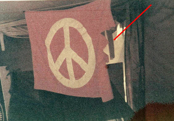 Passing through
Battalion clerk was a CO (Conscientious Objector) who had the flag over his bunk…nice kid; did my Code book cover.  But this incident told him  what “Charlie” thinks of his  “Peace Flag”.  The B-40 went through flag and passed out of the Tent.

