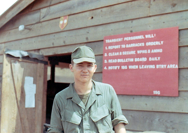 January, 1969: Back to Camp Enari
January, 1969.   Been assigned to work with the 1/69th Armor once again.  The sign behind me says:
ALL TRANSIENT PERSONNEL WILL
1. REPORT TO THE BARRACKS ORDERLY
2. CLEAN & SECURE WPNS & AMMO
3. READ THE BULLETIN BOARD DAILY
4. NOTIFY THE 1SG WHEN LEAVING THE AREA
