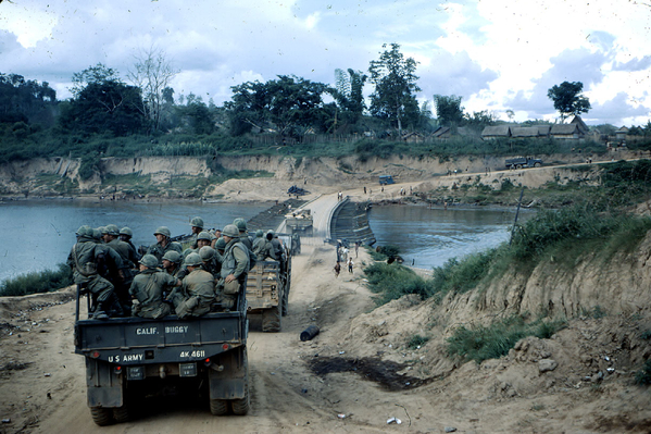 Convoy
Troops moving by truck with the villagers nearby.  Pontoon bridge ahead.
