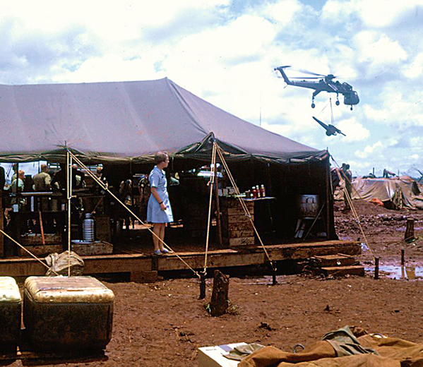 Curious
Another Donut Dolly (Linda) observes a Sikorsky Sky Crane haul a 105mm howitzer.  Jenny believes this photo may have been taken at LZ Highlander Heights, Mary Lou or Bison, but definitely in the 4th Inf Div Area of Operations.
