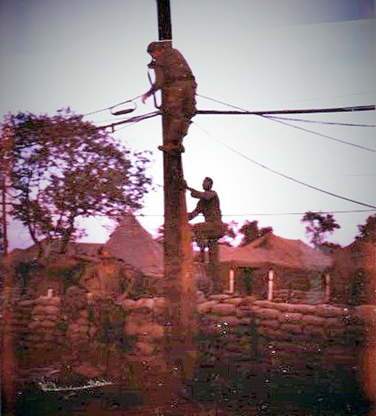 After Mother's Day Attack
Steven Cox at the Oasis, on the pole after the Mother's Day attack at LZ Oasis. We are fixing the cable that was cut the night before. One of the men on the shown below me is the Commo Sgt.  This photo was taken with a Polaroid I had to work on it to get it this good.
